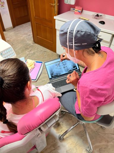 Dentista muestra una radiografía panorámica en un portátil a una paciente en Presencia Dental