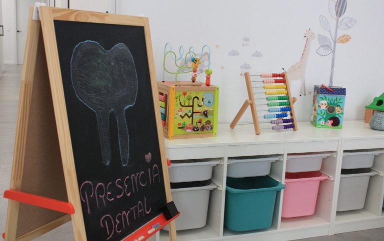Pizarra y juguetes en la zona infantil de la sala de espera de Presencia Dental